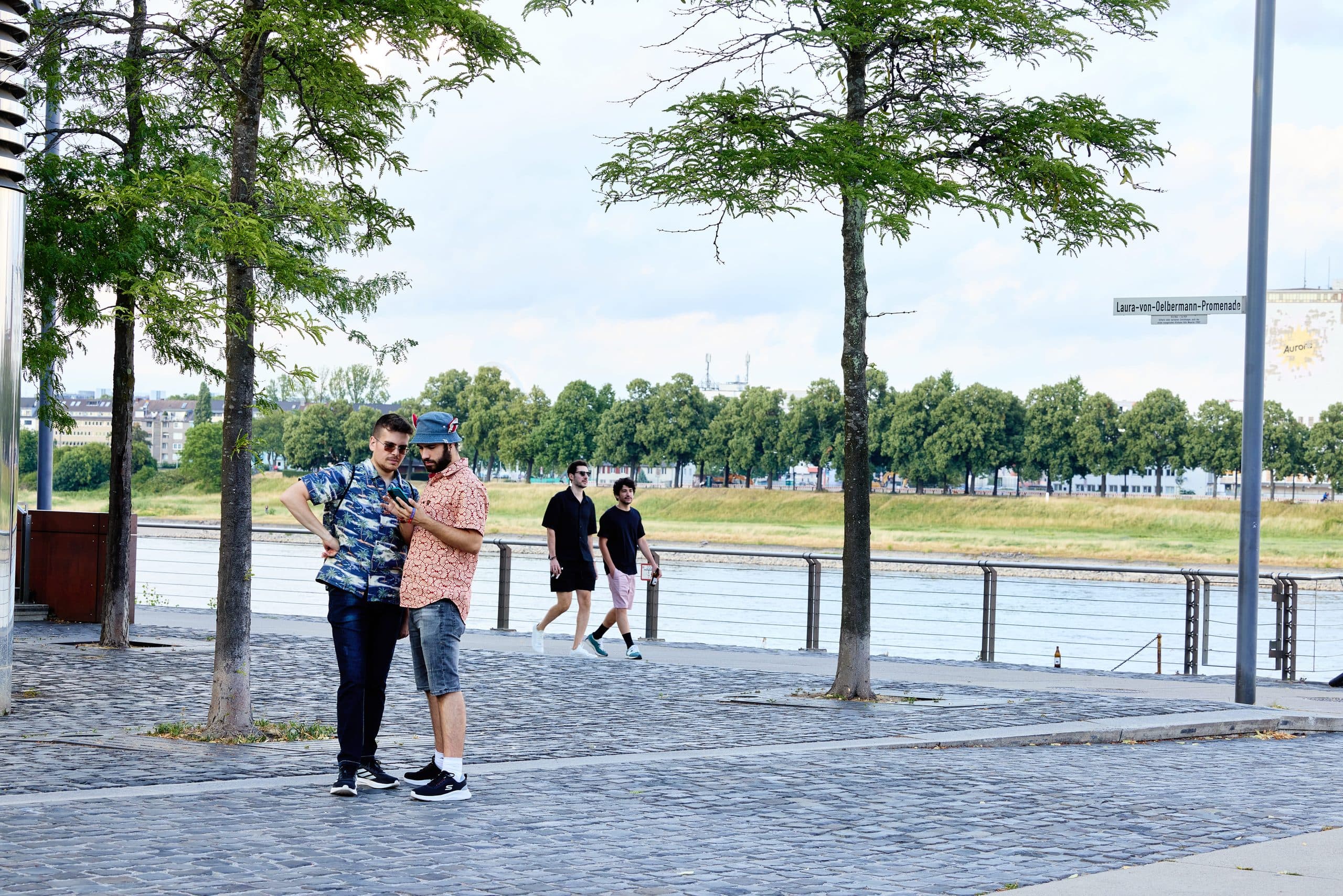 Der Rheinboulevard Süd mit Baum-Allee und Menschen am Rheinufer